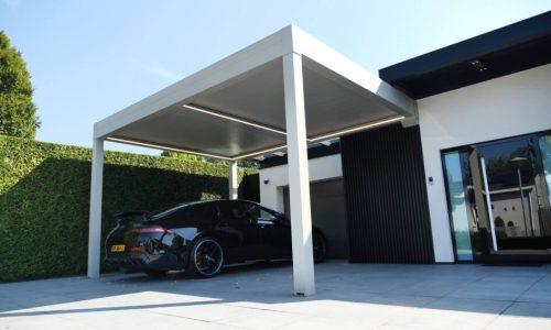 Weißer Carport unter blauem Himmel, unter dem ein Auto geparkt ist