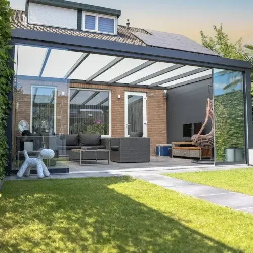 Veranda am Haus mit Glasdach in einem grünen Garten