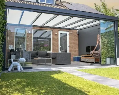 Veranda am Haus mit Glasdach in einem grünen Garten