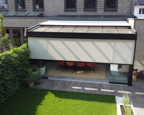 Halbgeschlossener Sonnenschutz auf einer Veranda mit Glasdach
